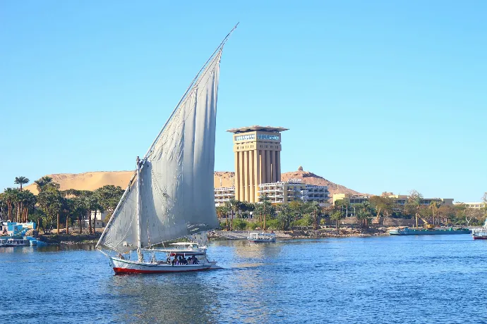 white sail boat on water near city buildings during daytime
